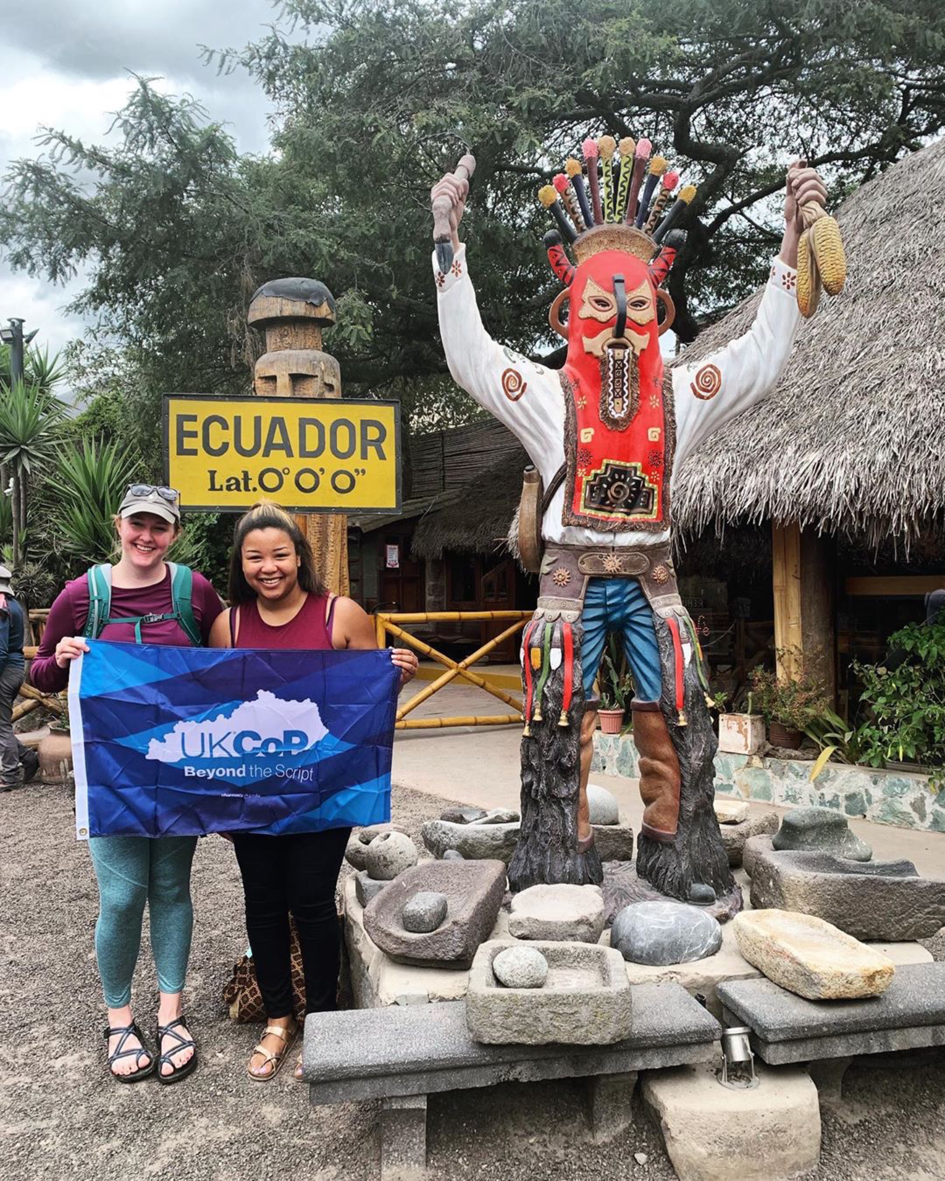 two students in ecuador with college flag