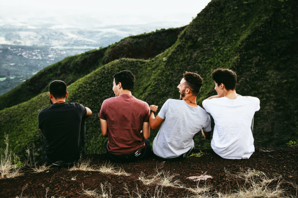 four guys overlooking a landscape viewing and laughing