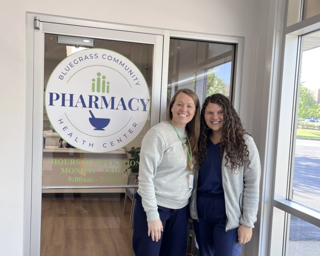 Molly Carr and Kelsie Skaggs pose in front of Bluegrass Community Health Center Pharmacy