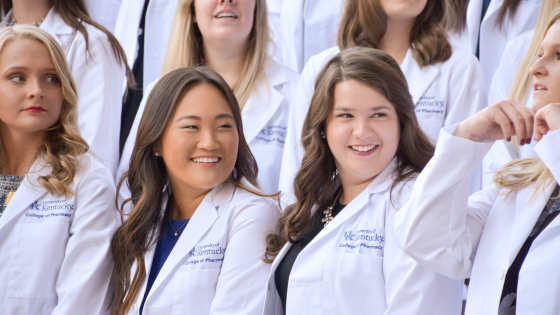 students standing in white coats outside
