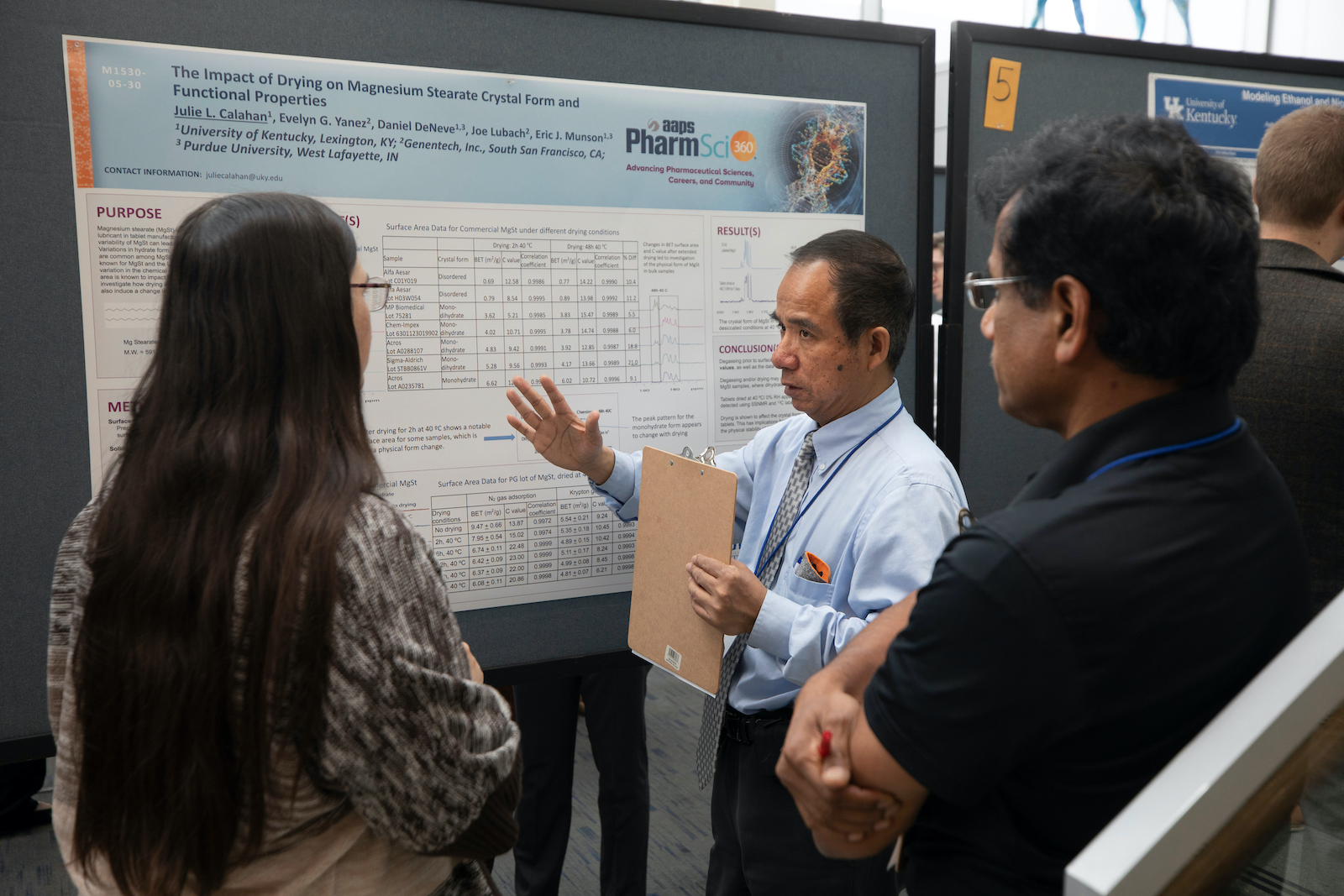 faculty member talking with poster presenter