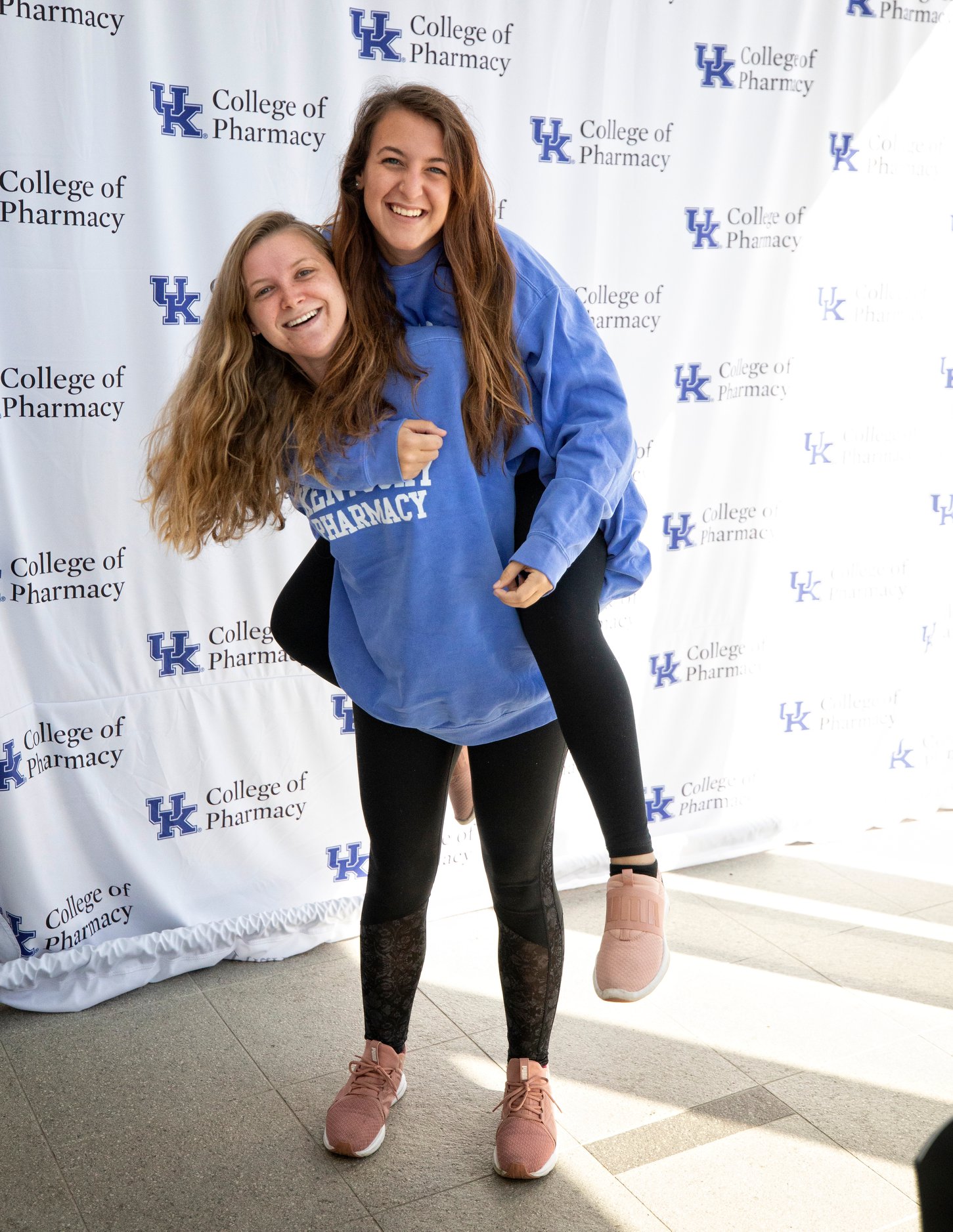 female students piggy-back smiling