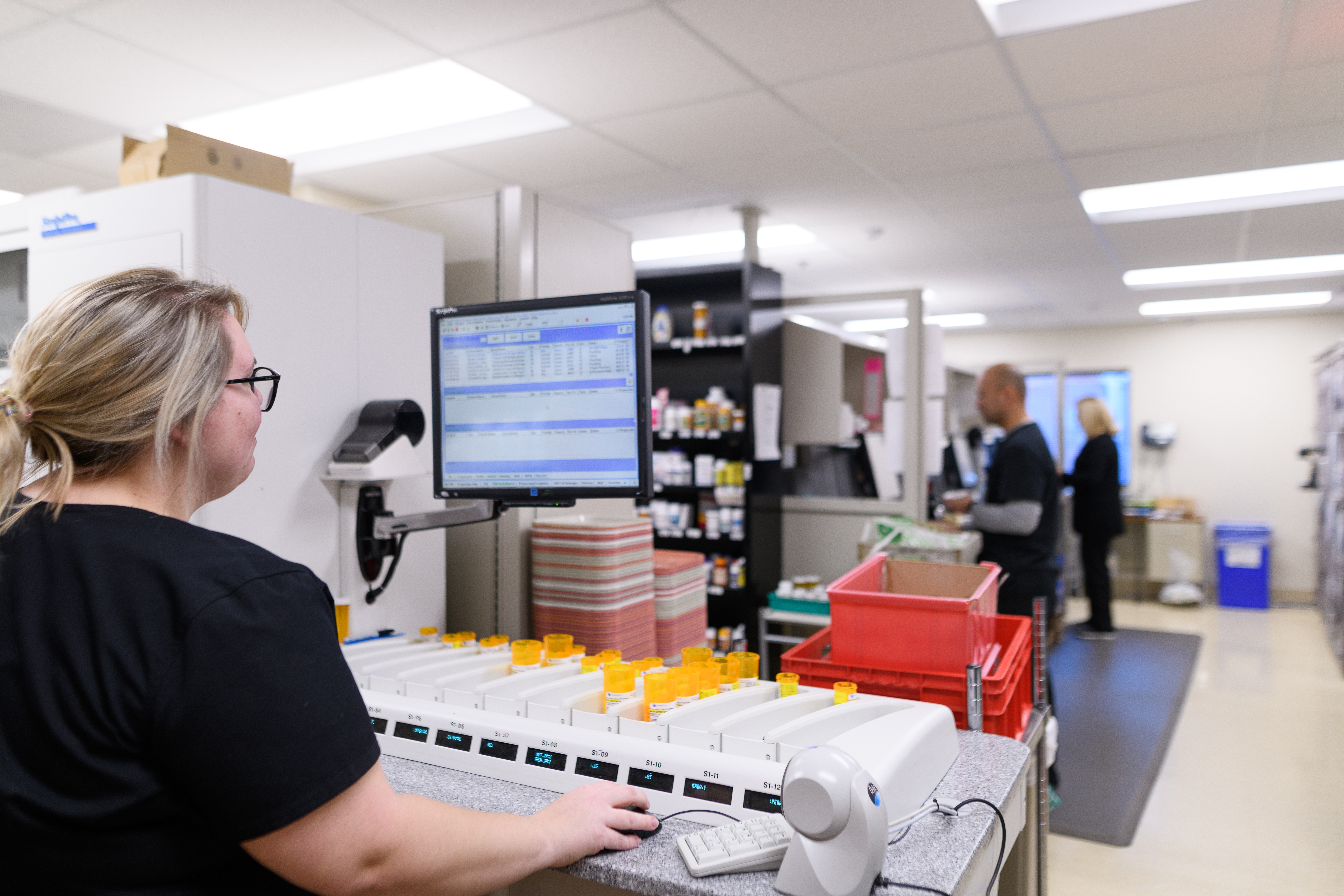 pharmacy student working at computer in the back of a hospital pharmacy