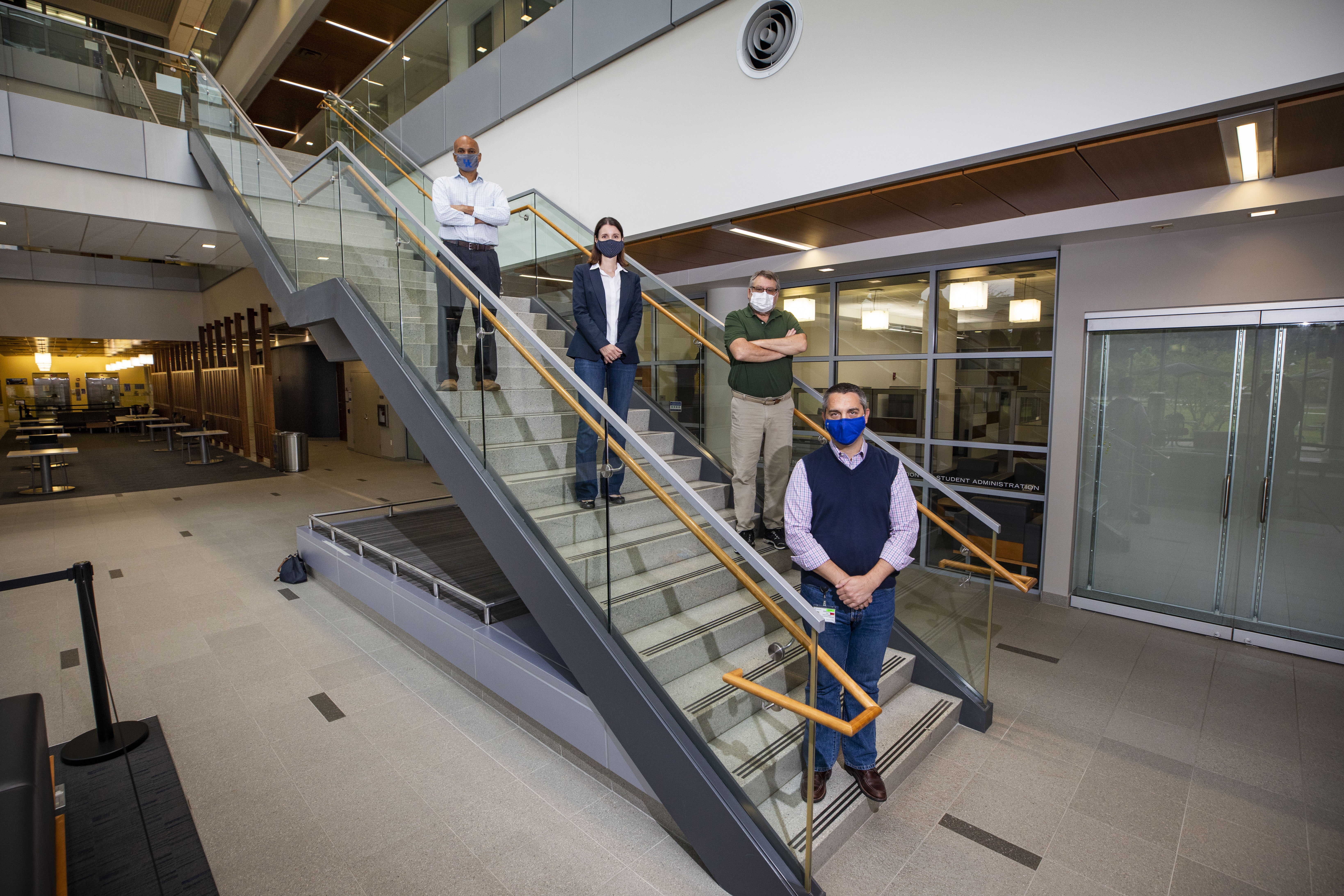 People in masks standing on stairs