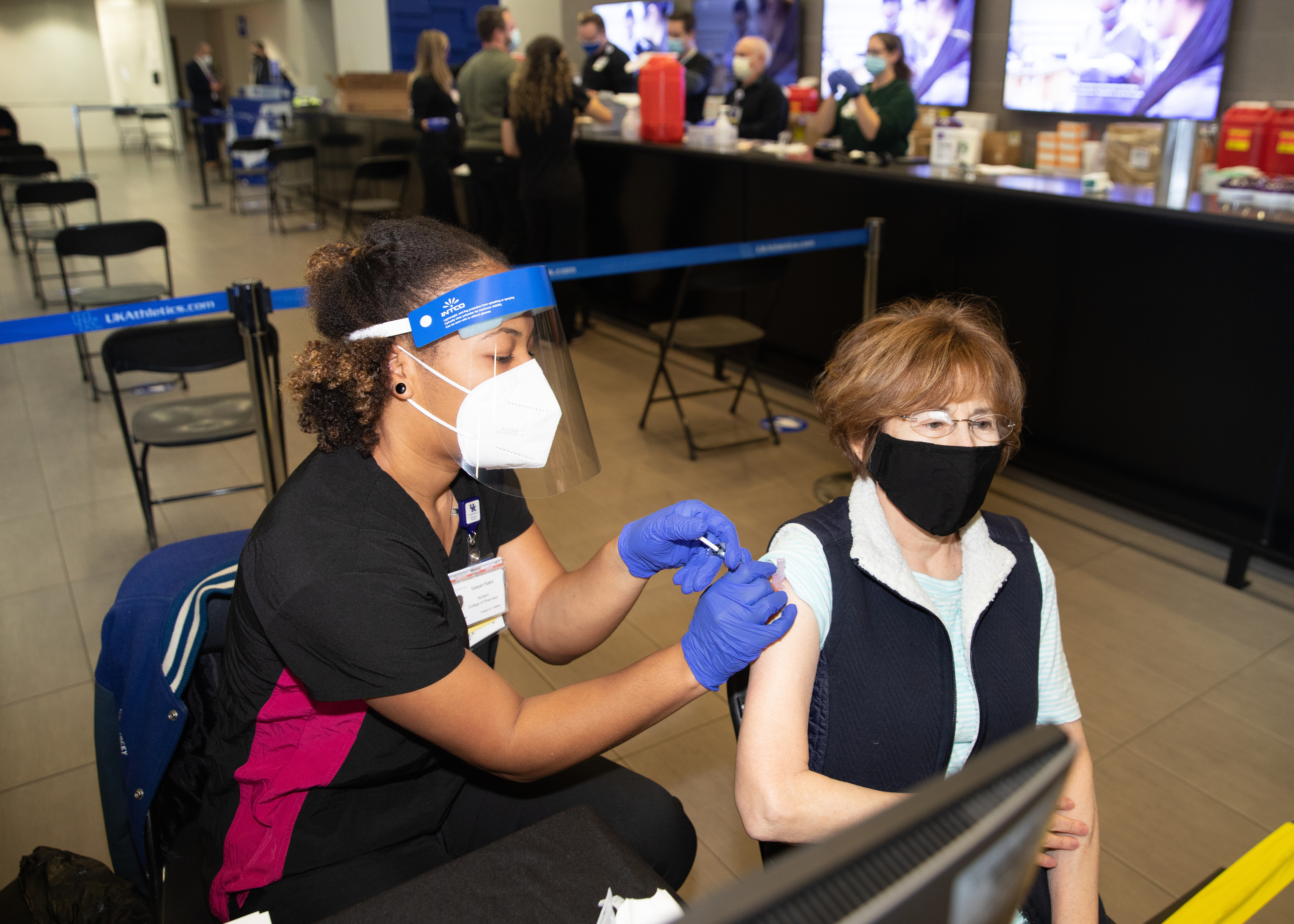 71 year old Gale Bhattacharyya, receives the Covid-19 vaccine from Tamyah Pipkin at Kroger Field at the University of Kentucky 