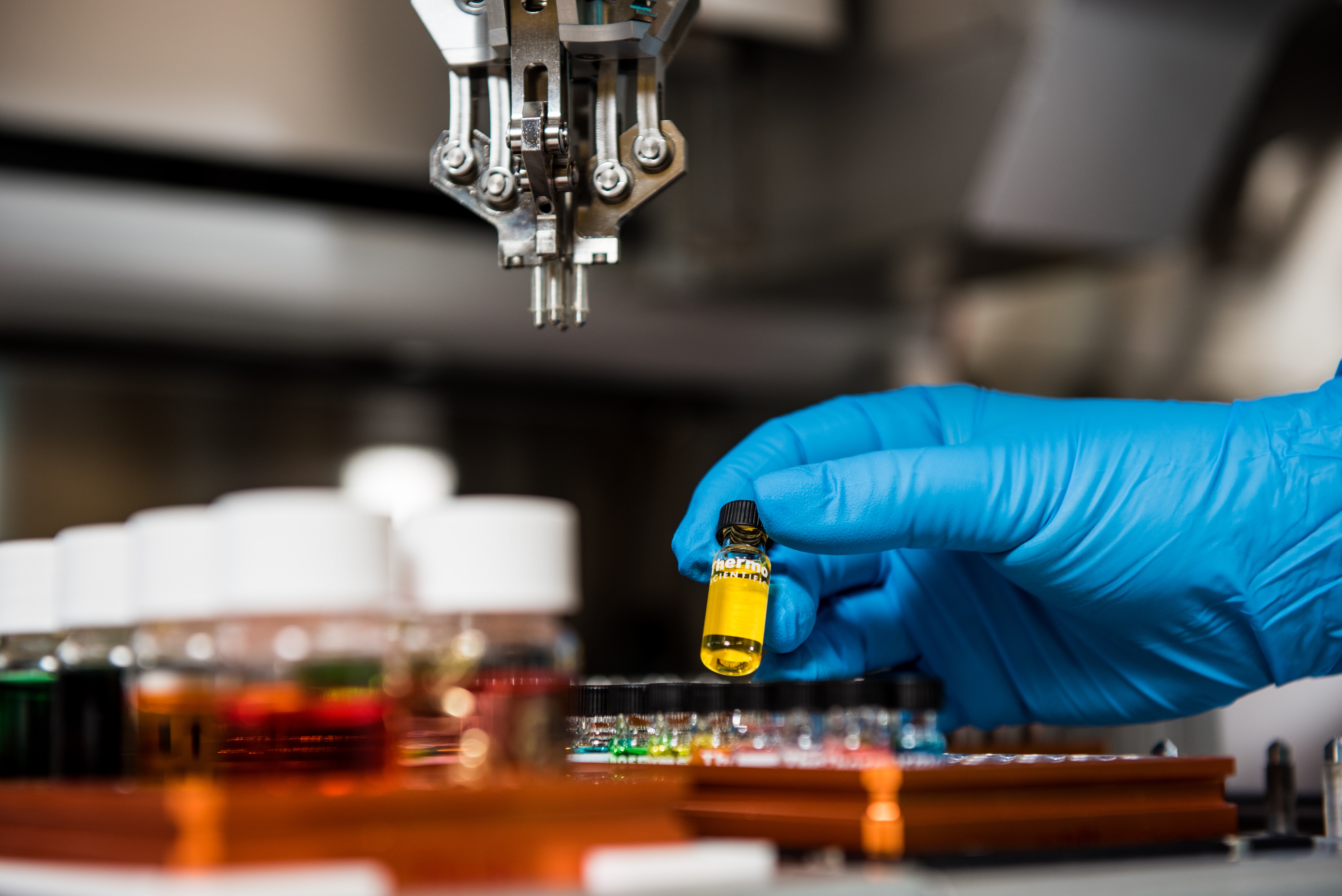gloved hand placing test tube in rack