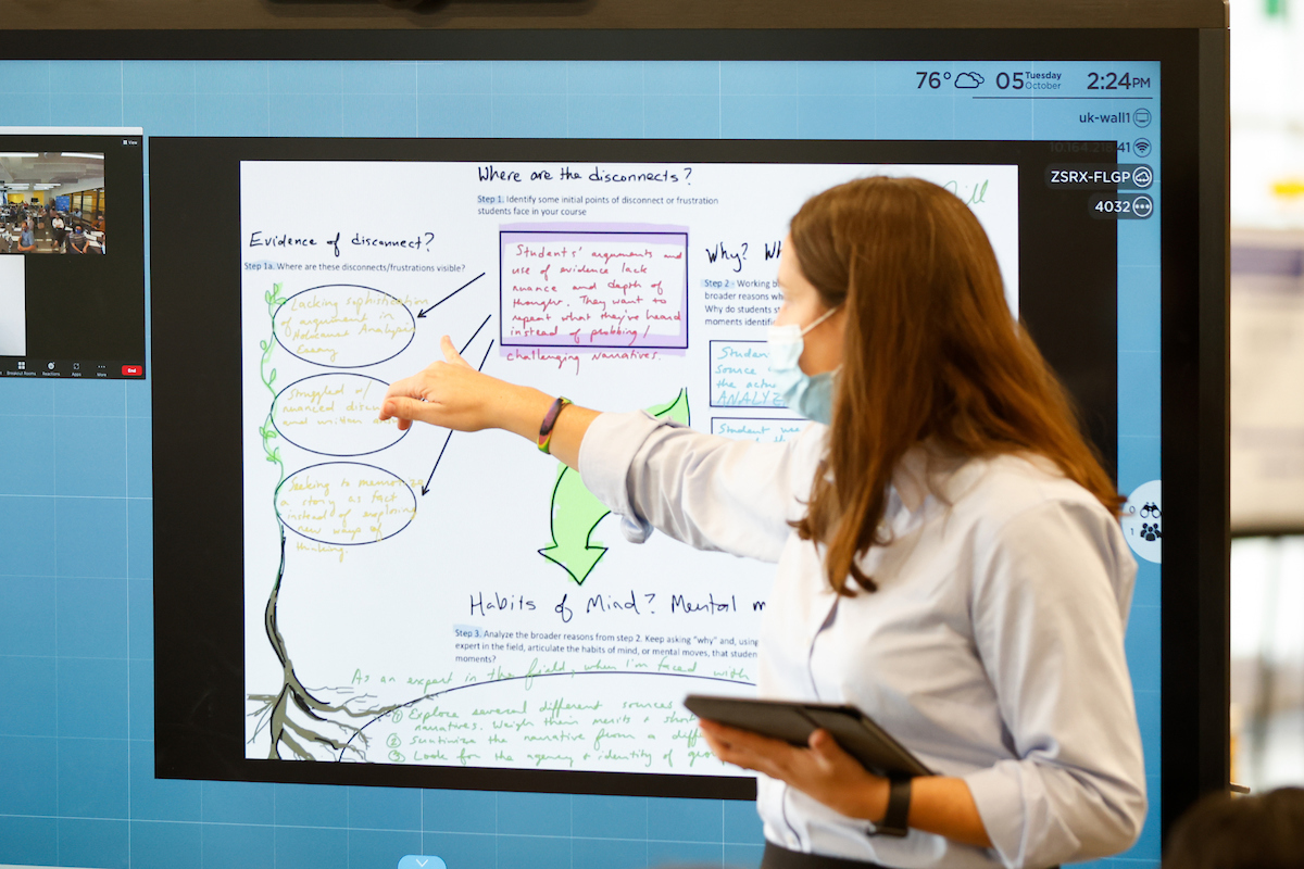 Woman pointing at digital board with notes