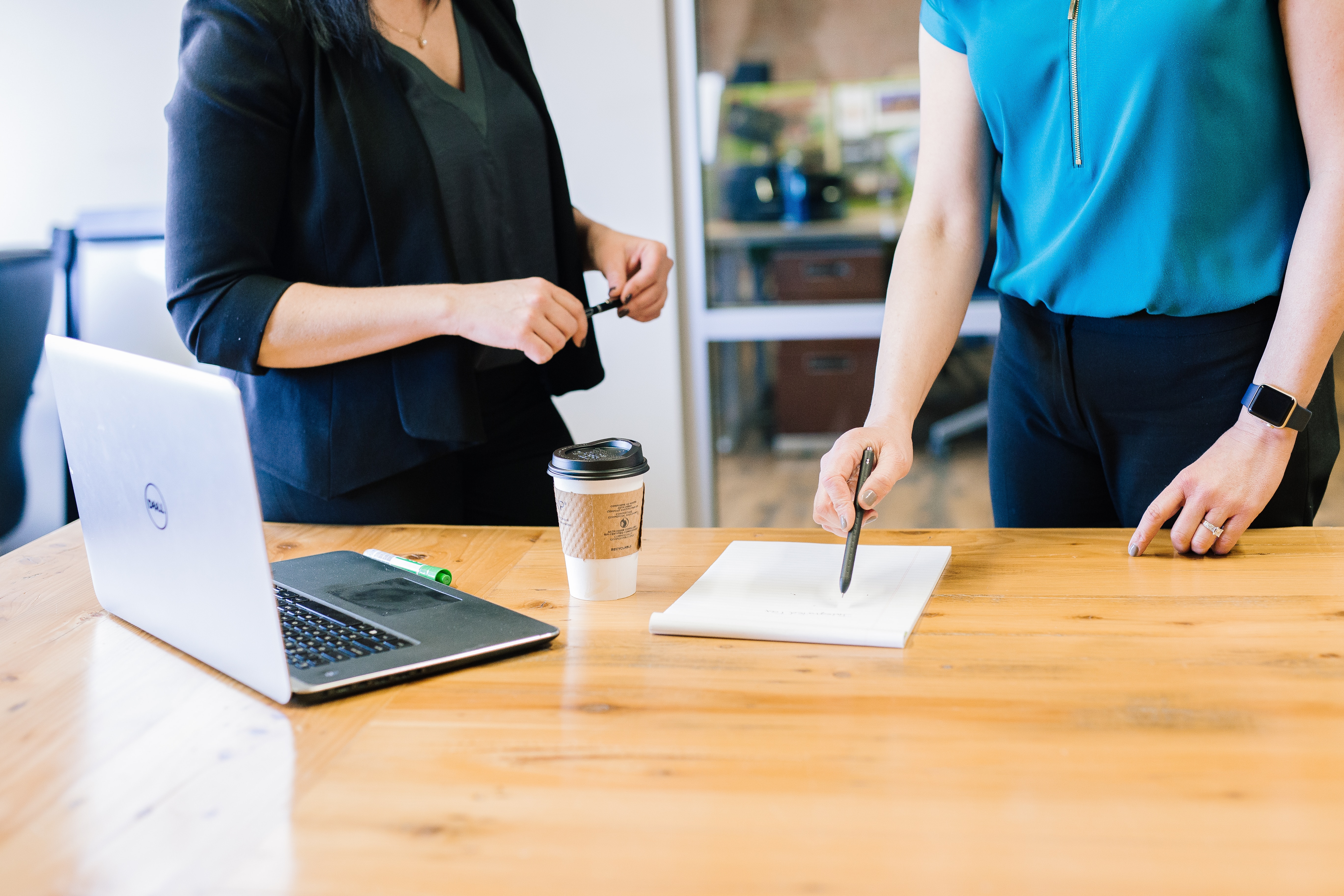 One person pointing at a piece of paper explaining a concept to another