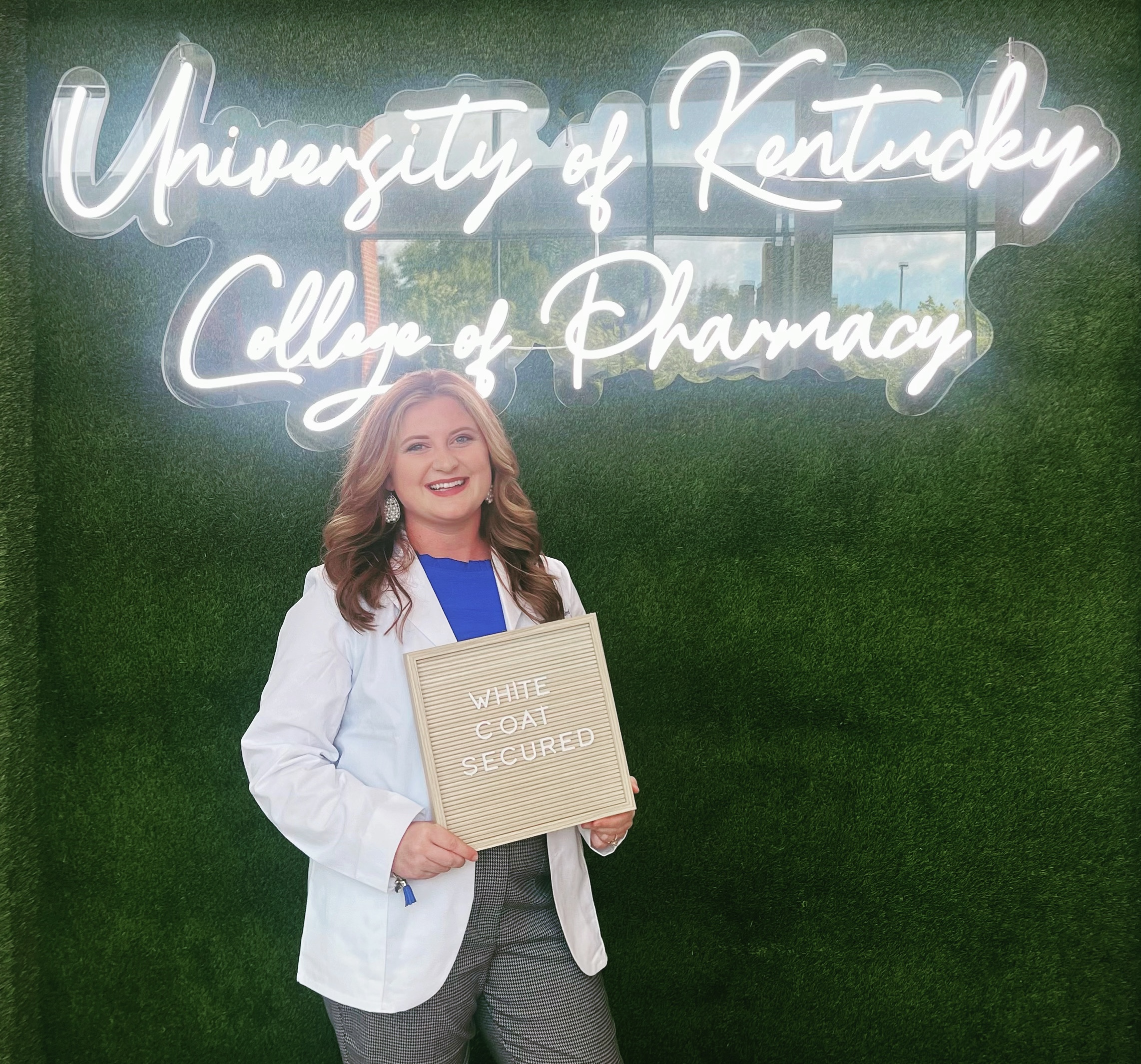 student posing in their new white coat