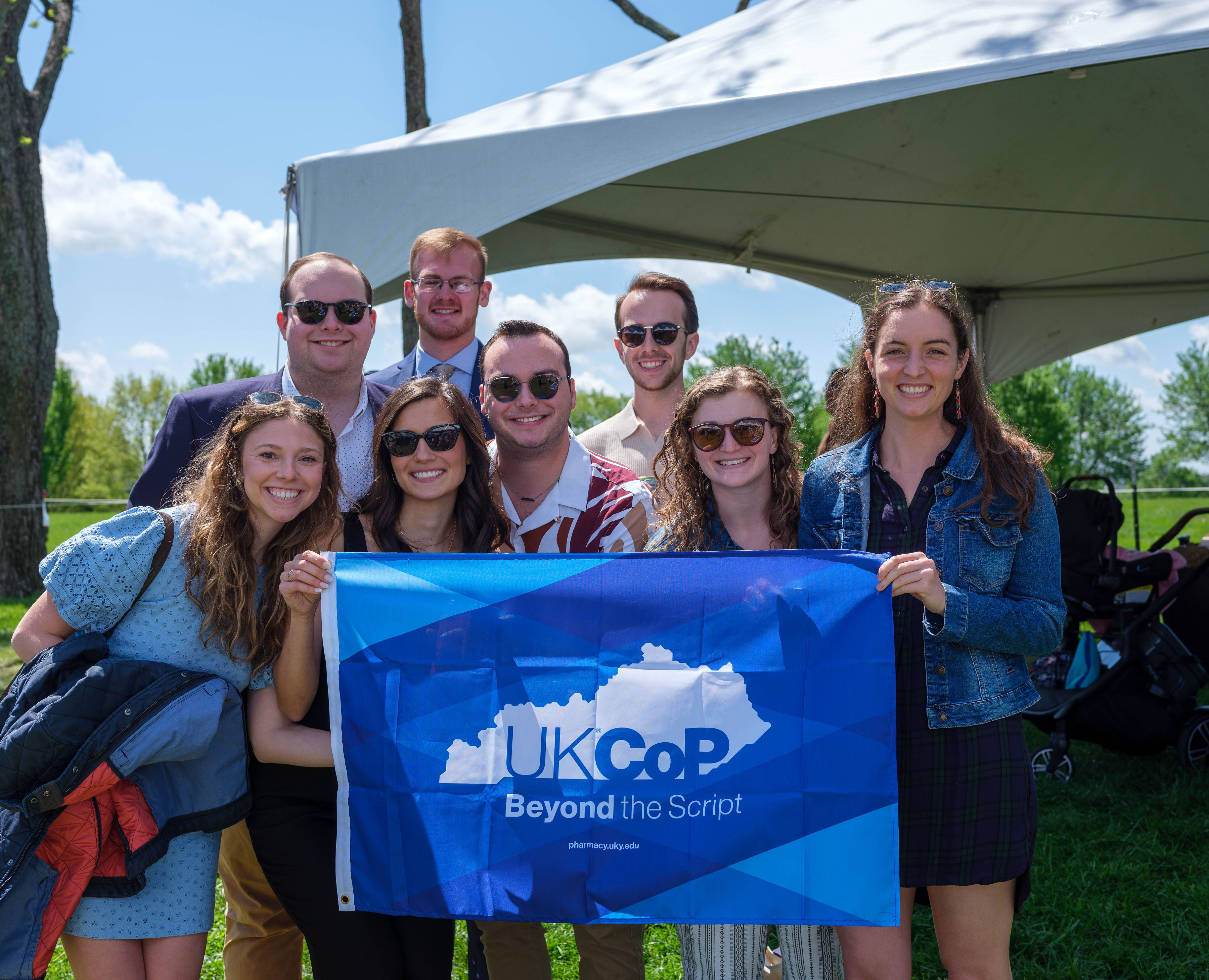 students at keeneland holding up the UKCOP flag