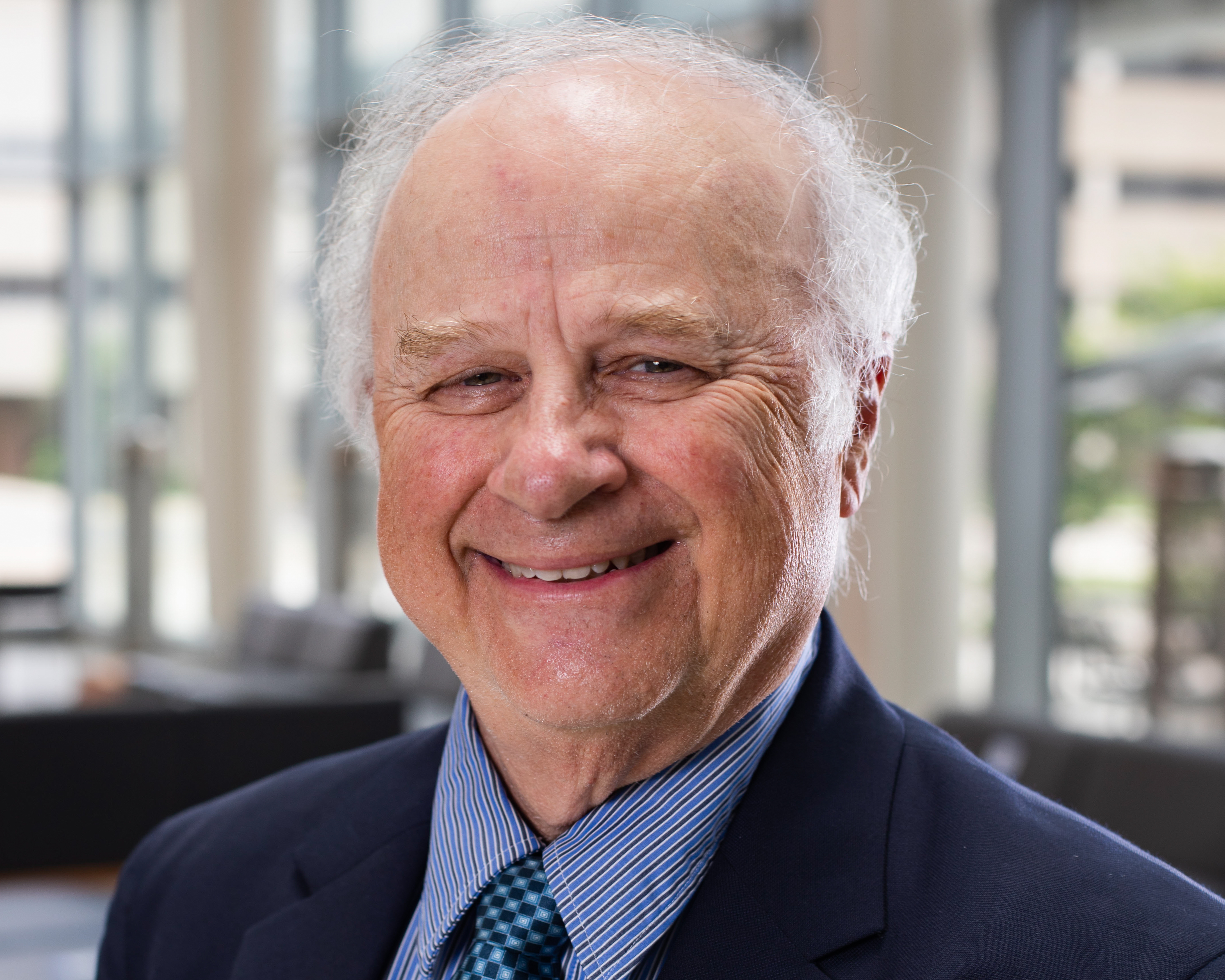 A man in a suit and tie smiling at the camera