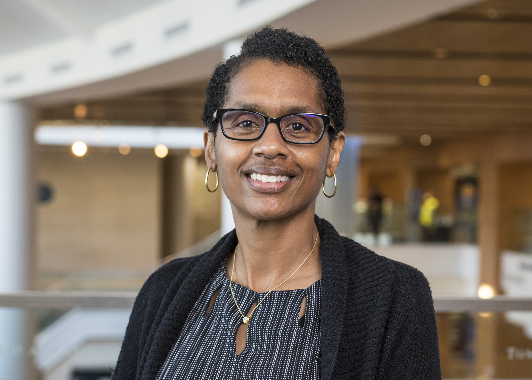 A woman wearing glasses smiling at the camera