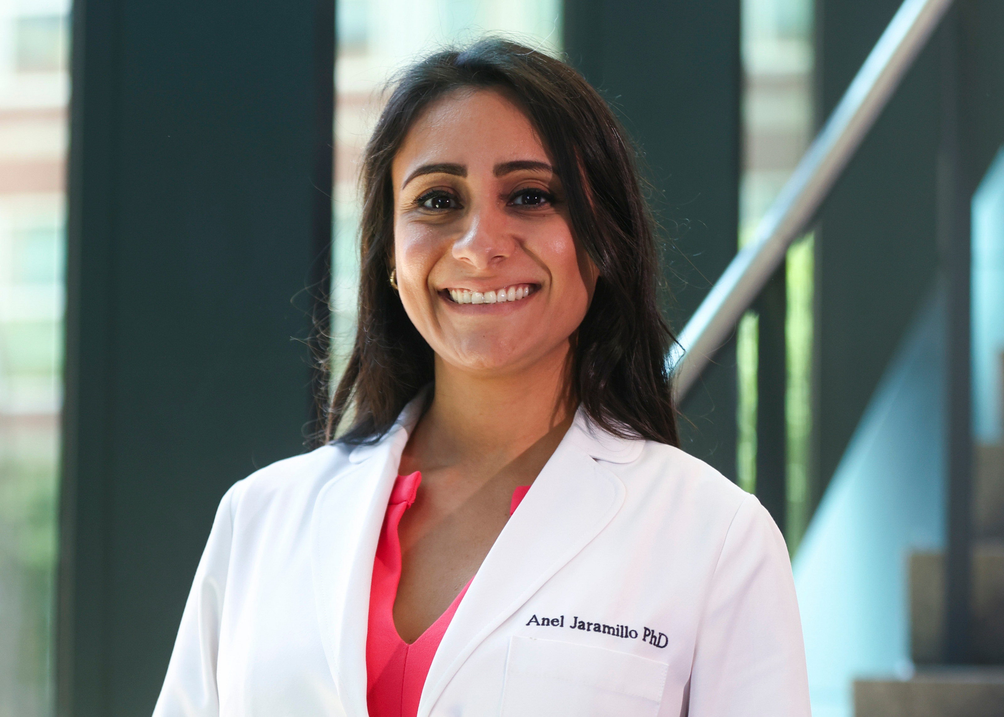 A woman in a white coat smiling