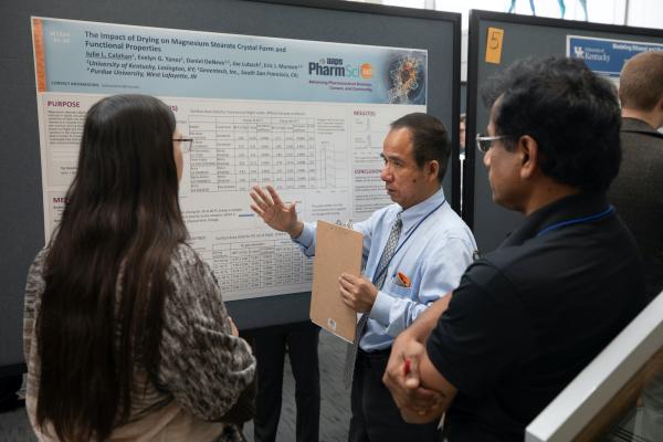 faculty member talking with poster presenter