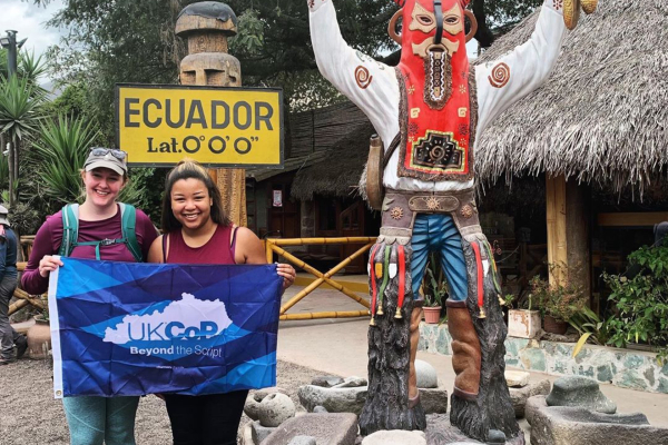 two students in ecuador with college flag