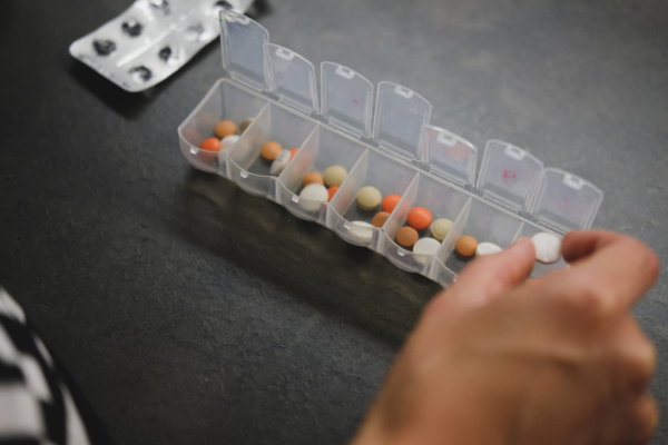 person sorting pills into a pill box