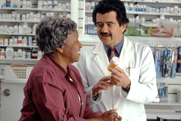 pharmacist showing woman a prescription bottle
