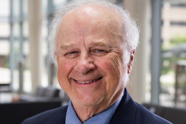A man in a suit and tie smiling at the camera