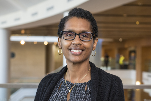 A woman wearing glasses smiling at the camera