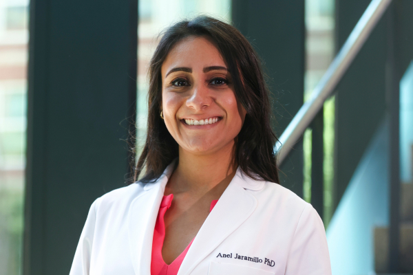 A woman in a white coat smiling