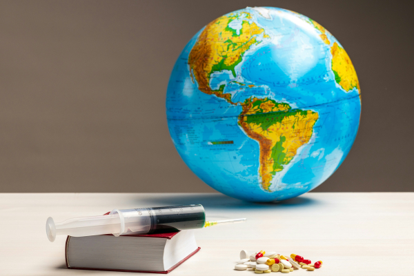 a globe, a syringe, some pills and a book