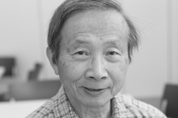 A man wearing a collared shirt smiling at the camera