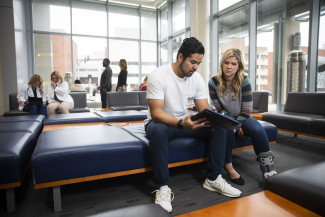 students sitting looking at a shared iPad