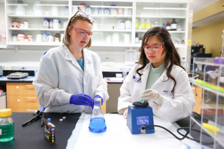 two students conducting a lab experiment