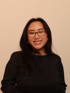 Woman wearing a black shirt and glasses and smiling