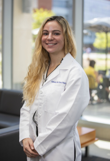 Woman wearing white lab coat smiling