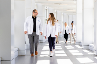 students in white coats walking