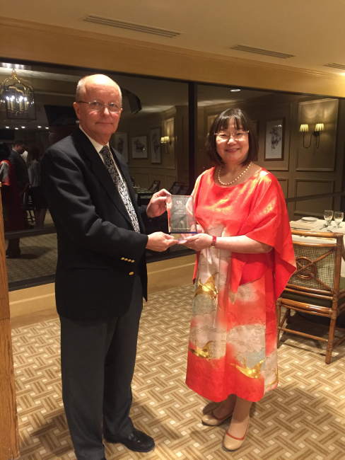 man and woman holding a glass award between them