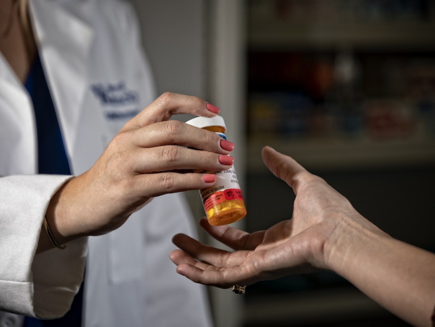 Handing over pill bottle