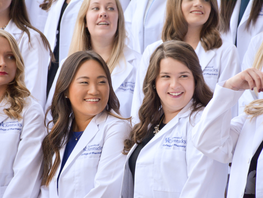 students standing in white coats outside