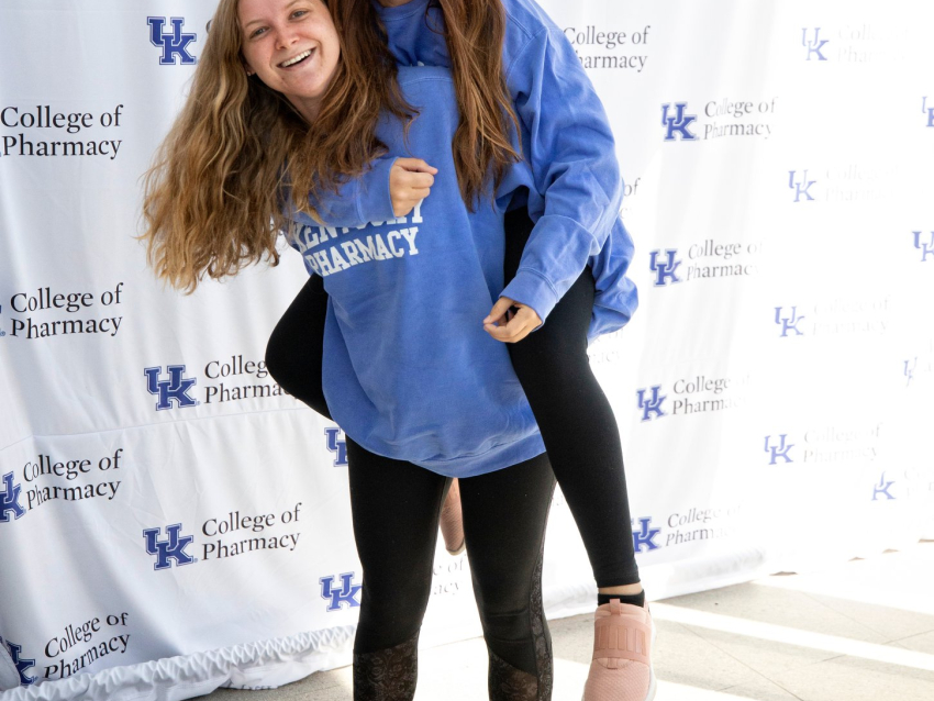 female students piggy-back smiling