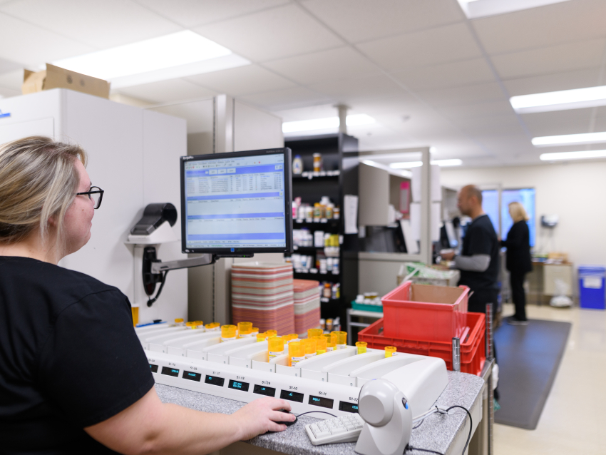pharmacy student working at computer in the back of a hospital pharmacy