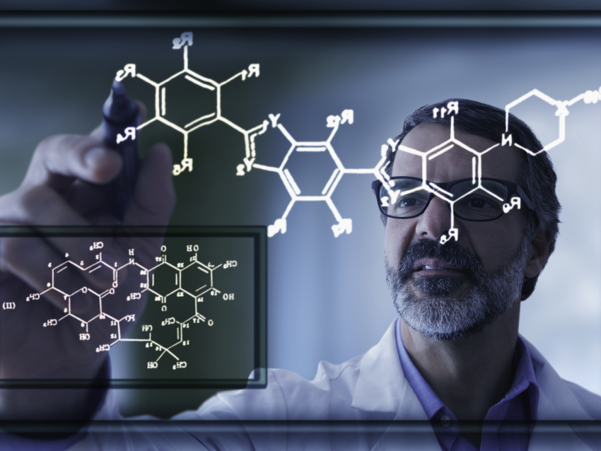person in white coat drawing a chemical