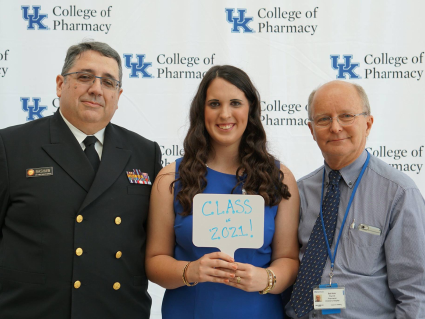 three people standing in front of UKCOP logo
