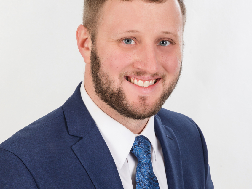 Ben Mudd headshot, wearing blue suit and blue tie