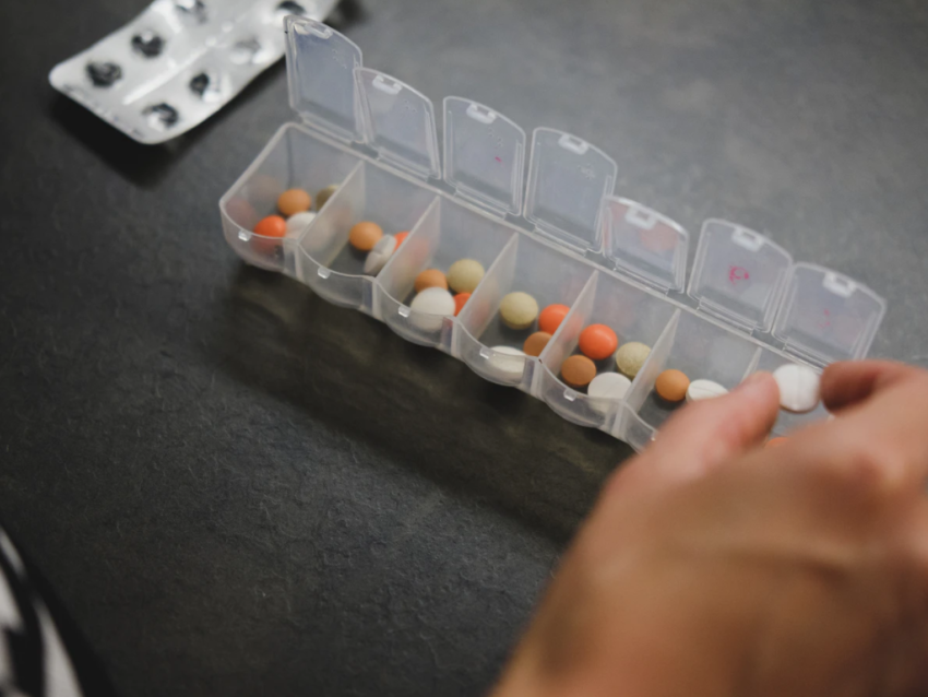 person sorting pills into a pill box