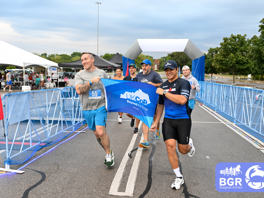 a group of men running as a team holding a UKCOP flag
