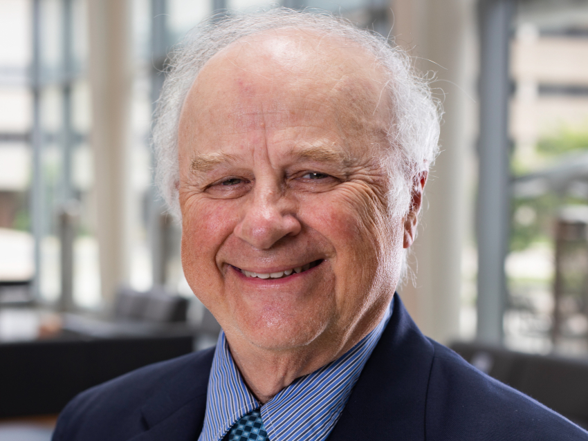 A man in a suit and tie smiling at the camera