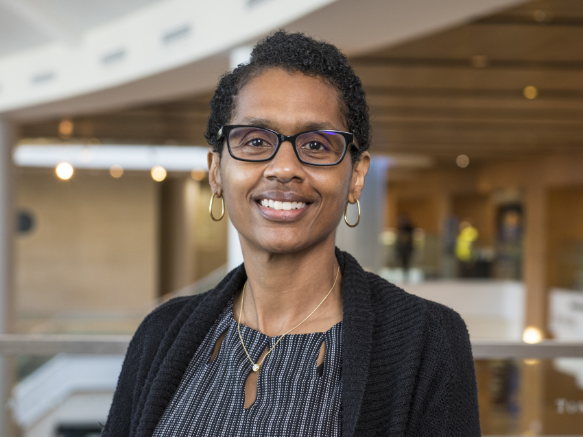 A woman wearing glasses smiling at the camera