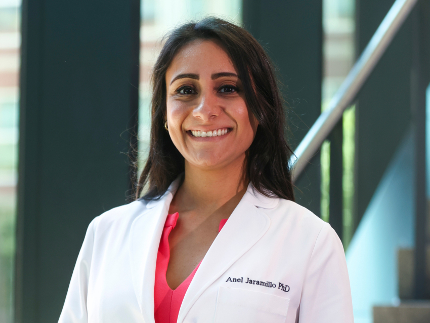 A woman in a white coat smiling