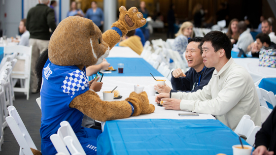 wildcat sitting and laughing with students