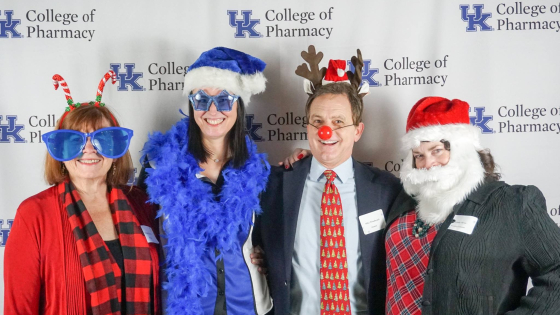 4 people dressed in goofy holiday outfits