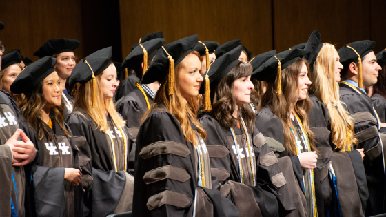 students standing in full pharmacy regalia