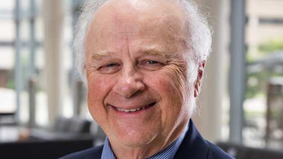 A man in a suit and tie smiling at the camera