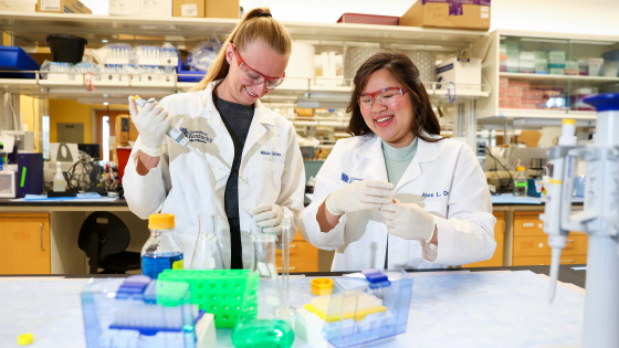 two students in a lab conducting experiments