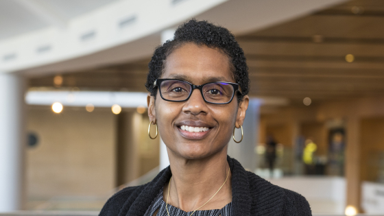 A woman wearing glasses smiling at the camera